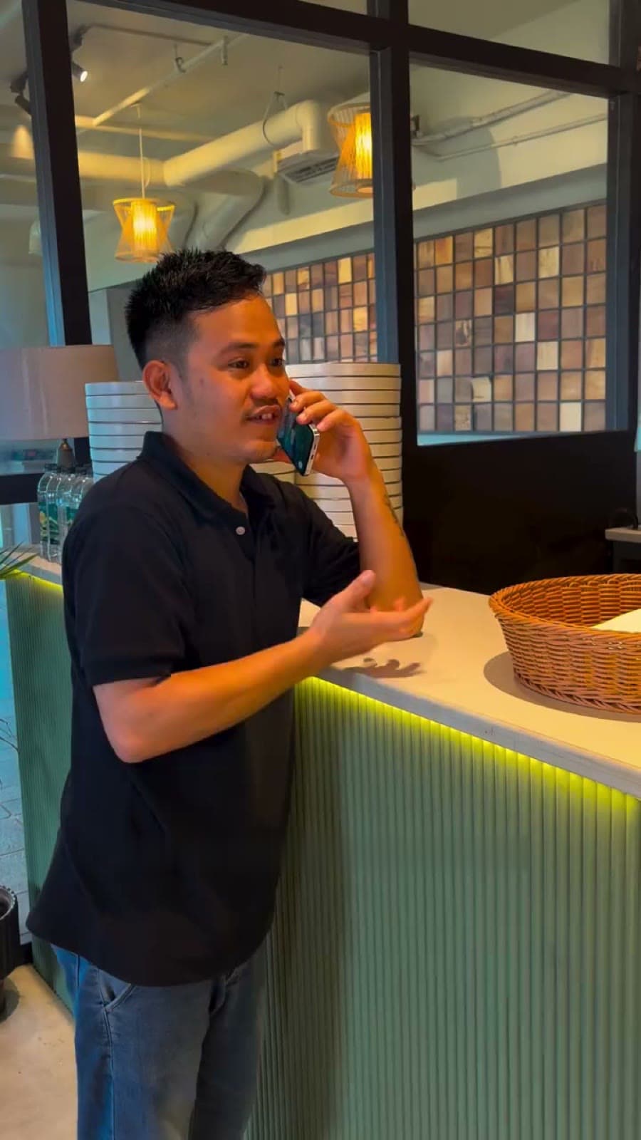 A Cafe!n barista on the phone at the fluted sage-green counter