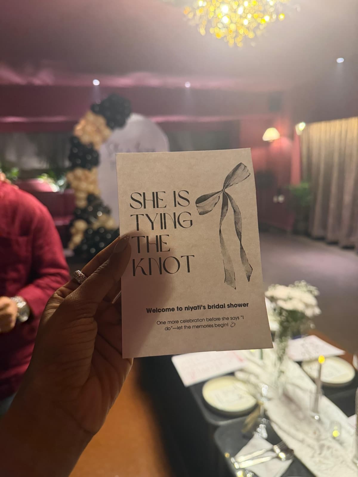 A she is tying the knot invitation card at a bridal shower