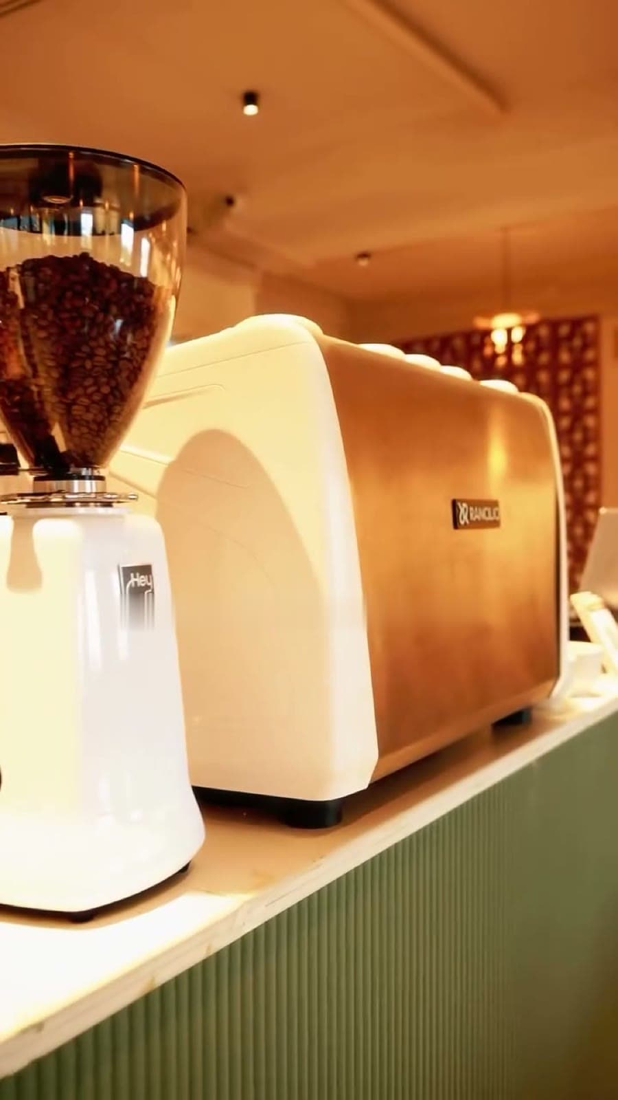 HeyCafé grinder and espresso machine on the sage-green coffee bar