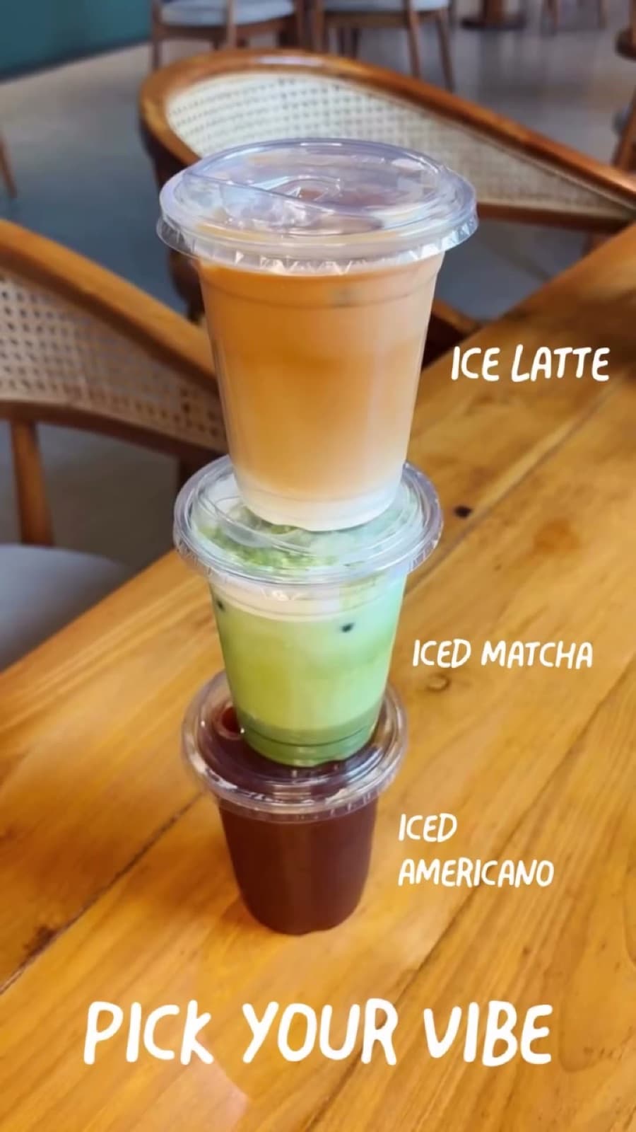An iced latte, iced matcha and iced Americano stacked on a wooden table — pick your vibe