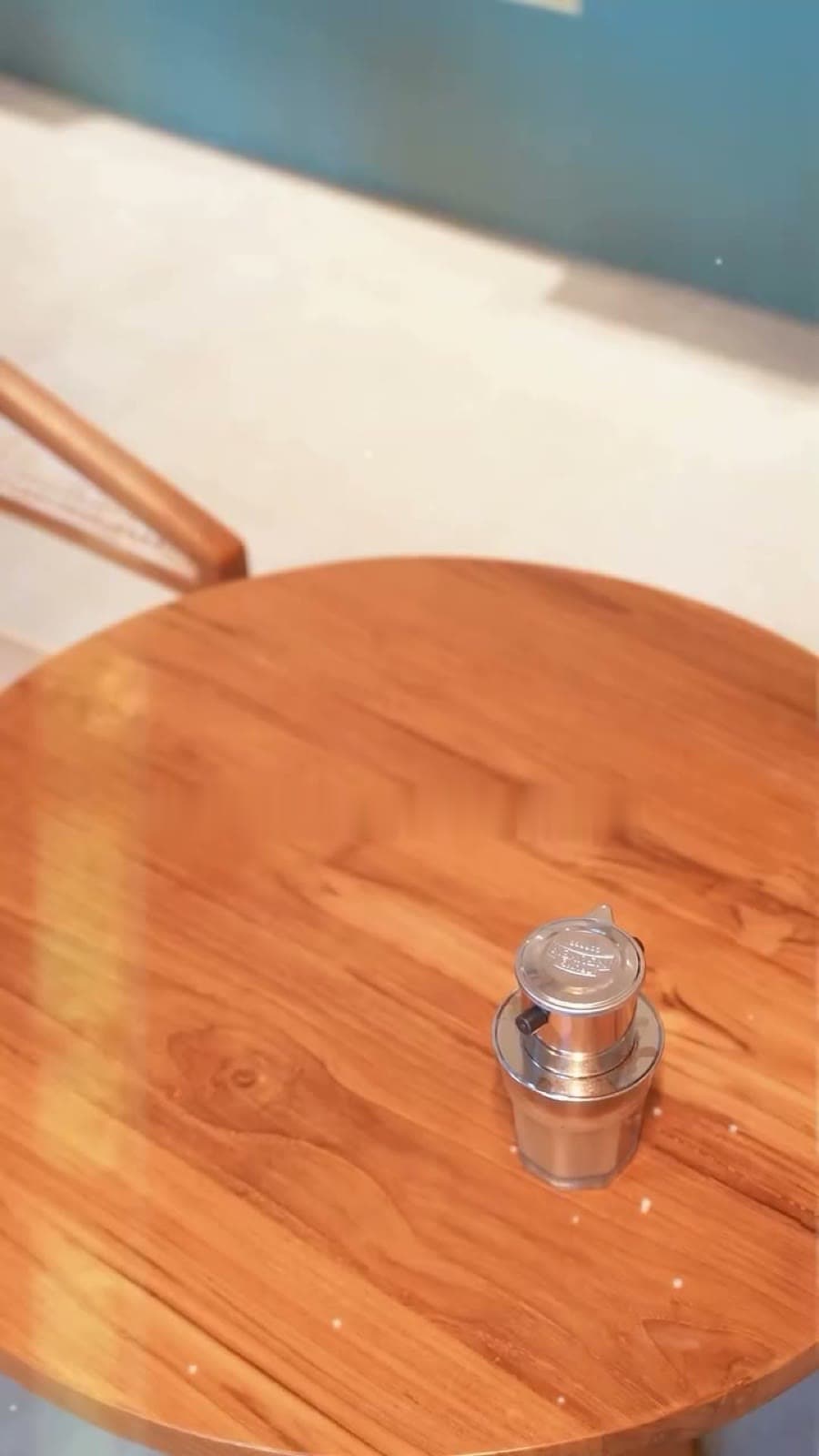 A Vietnamese phin filter on a round teak table