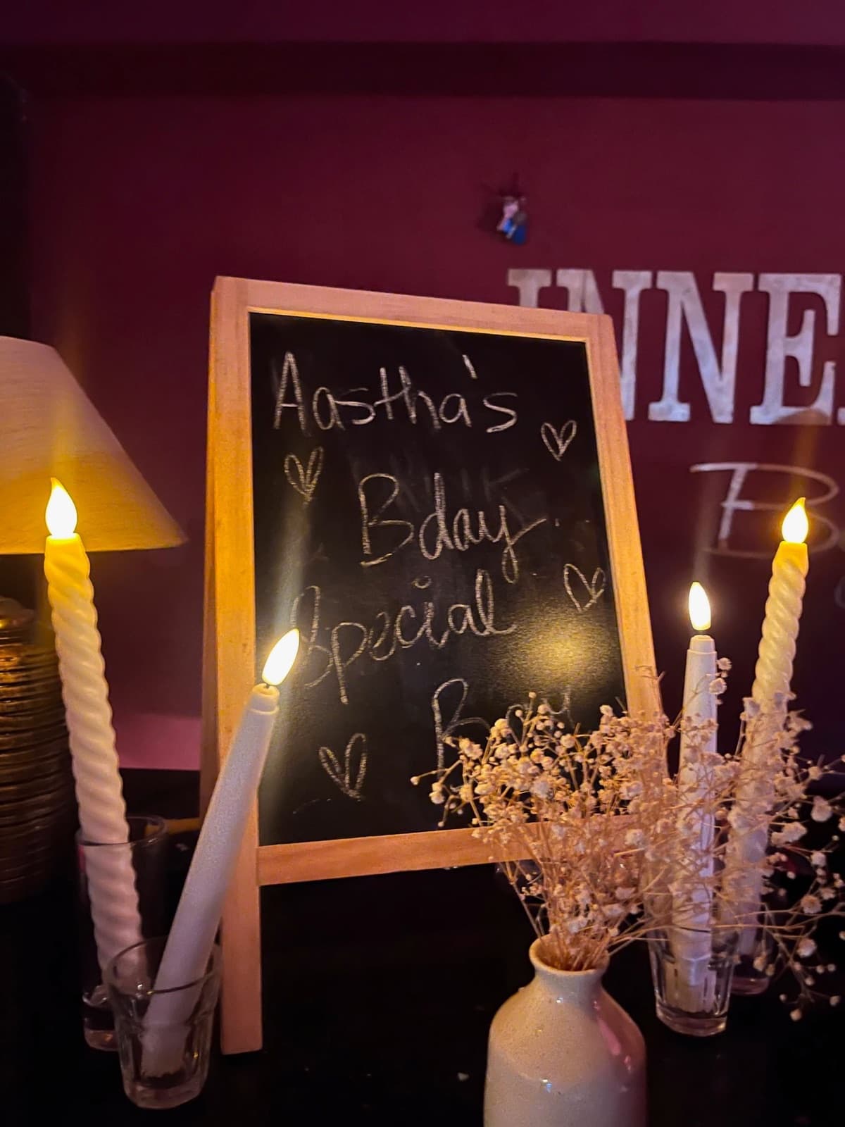 A hand-lettered birthday chalkboard between tall white candles